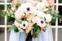 a catchy wedding bouquet of white anemones, peachy and blush roses and peonies, fern and berries and some eucalyptus is wow