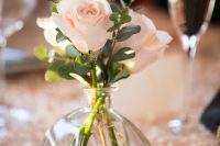 a chic and simple wedding centerpiece of a vase with blush roses and eucalyptus is a stylish and cool idea for a wedding