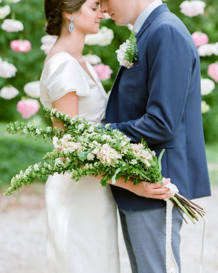 a chic and stylish bridal look with a ilk wedding dress and a dreamy long stem white and blush wedding bouquet