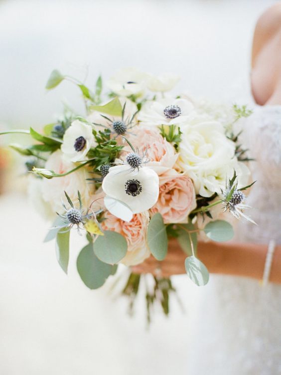 a chic pastel wedding bouquet of white anemones and roses, pink peonies, greenery and thistles is a lovely idea for spring