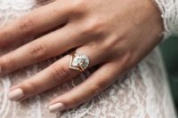 a chic white pear-shaped diamond wedding ring in a stack with a triangle mini diamond one and a lower arched ring with diamonds