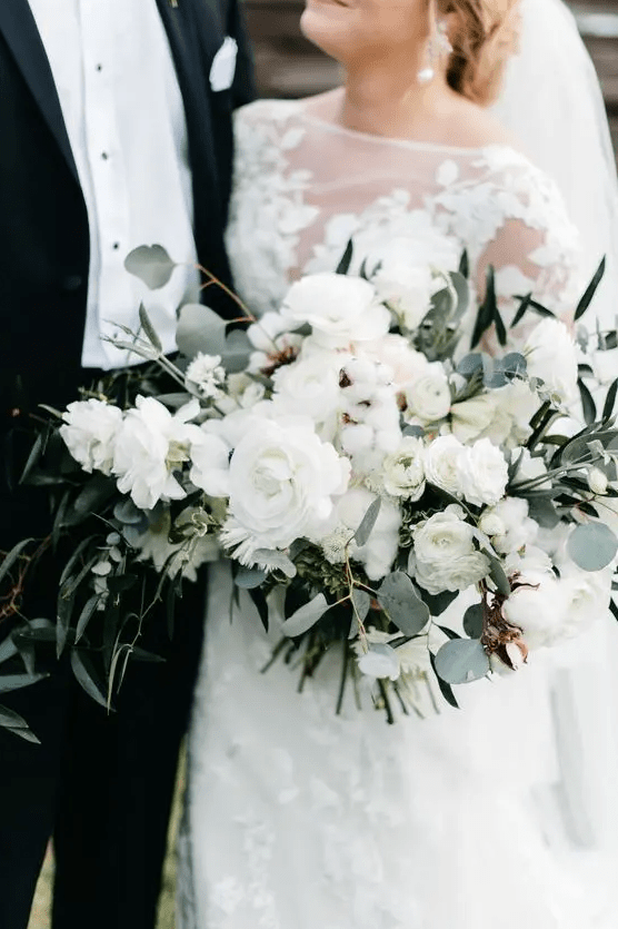 A classic all white wedding bouquet with ranunculus, cotton, roses, greenery is a gorgeous idea for many weddings
