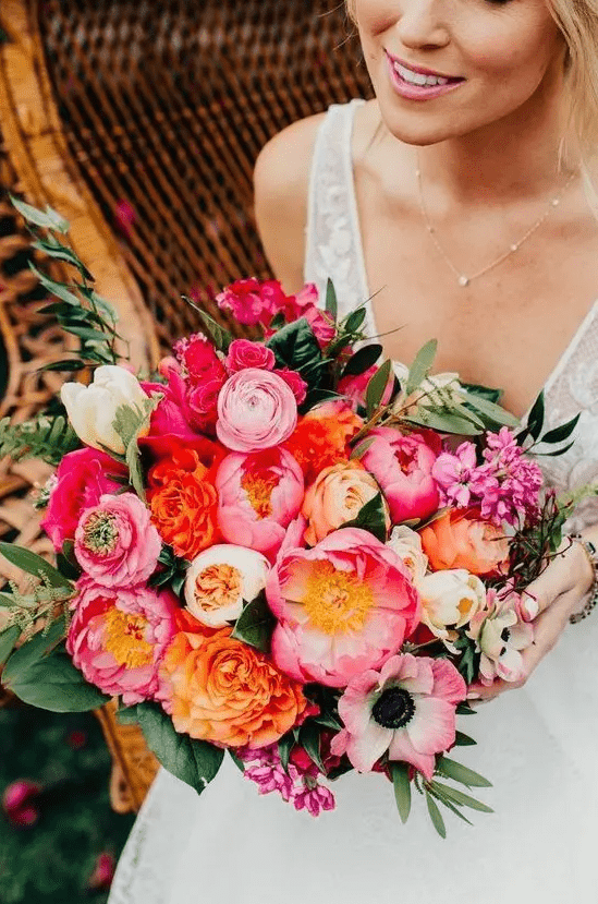 a classy wedding bouquet with pink, orange, light pink and white blooms and greenery for a bright wedding