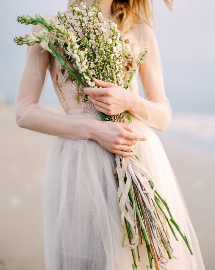 a coastal bride rocking a long stemmed wedding bouquet with small blooms is a very delicate and chic idea to rock