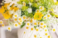 a colorful wedding centerpiece that includes daisies, some yellow and white blooms is a super cool and relaxed wedding decoration idea