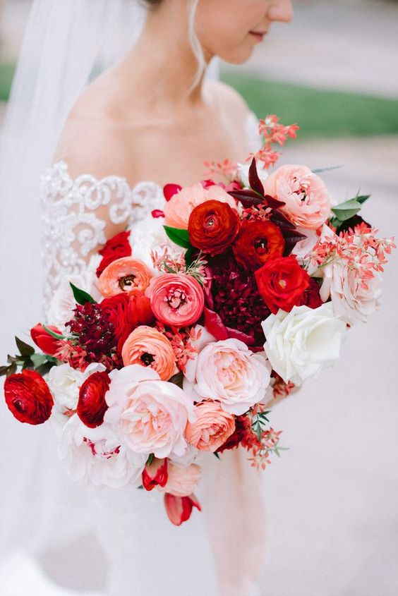 a contrasting wedding bouquet of blush and white roses, red, blush and white ranunculus and some fillers