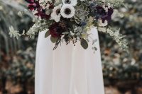 a cool wedding bouquet of white anemones, burgundy blooms, succulents, berries and blooming branches is ideal for fall