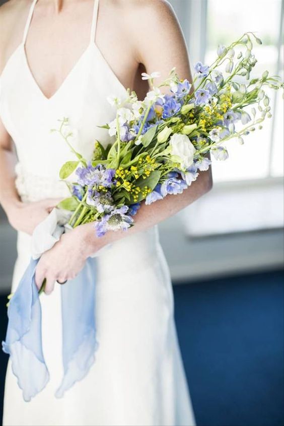 a cute and simple summer wedding bouquet of white roses and blue delphinium is a chic and cool idea for spring or summer