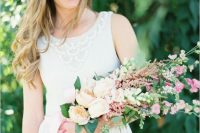 a delicate wedding bouquet of blush peonies, small pink blooms and greenery and blush ribbons for a lovely summer wedding