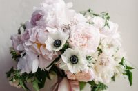 a delicate wedding bouquet of pink peonies and white anemones, pink ribbons and some greenery is ideal for spring or summer