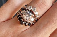 a gorgeous stacked wedding ring with a central band with a large round diamond and two smaller ones, two arched rings with black and white diamonds, arched bands with larger diamonds