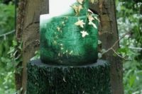 a jaw-dropping enchanted forest wedding cake with a dark green ruffle, an ombre green and white tiers, with gold edible leaves