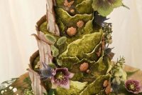 a jaw-dropping enchanted forest wedding cake with green moss-like buttercream tiers, thistles, butterflies, blooms and greenery just wows