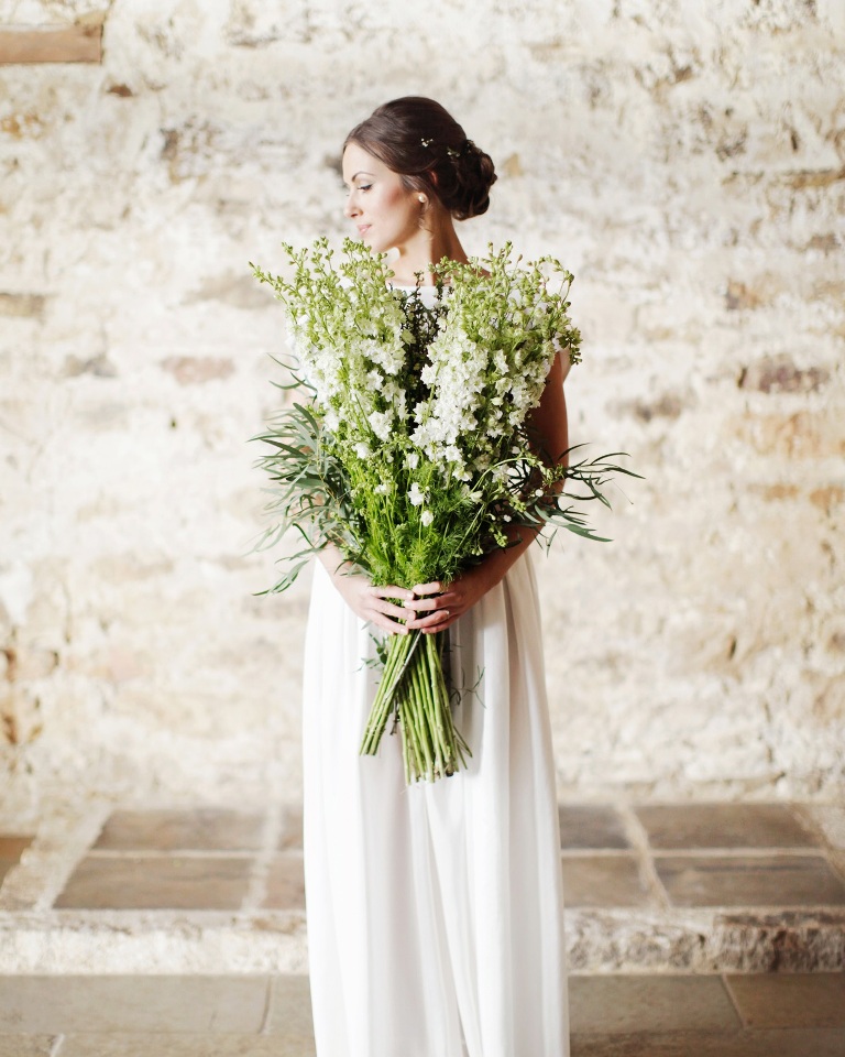 A large white bloom and greenery and grass long stem wedding bouquet is a fantastic solution for a spring or summer bride