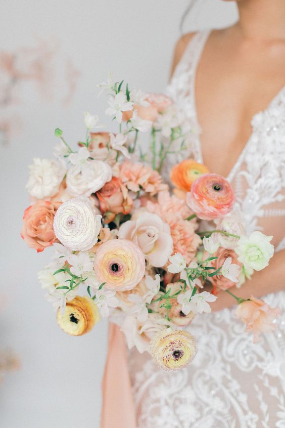 a lovely wedding bouquet with peachy, orange and white raunuculus, white fillers is a cool idea for a spring wedding