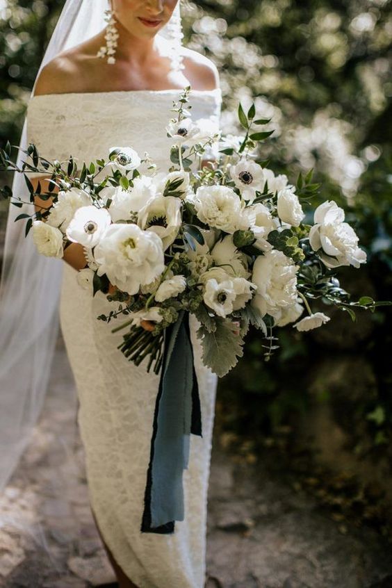 a lush and statement-like wedding bouquet of white peonies and anemones, greenery and blue ribbons is amazing for spring or summer