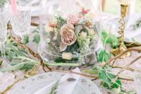 a neutral and chic secret garden wedding centerpiece of blush and pink blooms and greenery in a cloche is a veyr playful idea