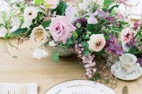a refined garden wedding centerpiece of blush, lilac and white blooms, purple flowers and greenery amazes and wows