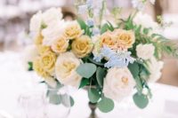 a refined secret garden wedding centerpiece of a bowl with neutral and yellow roses and some greenery is very chic