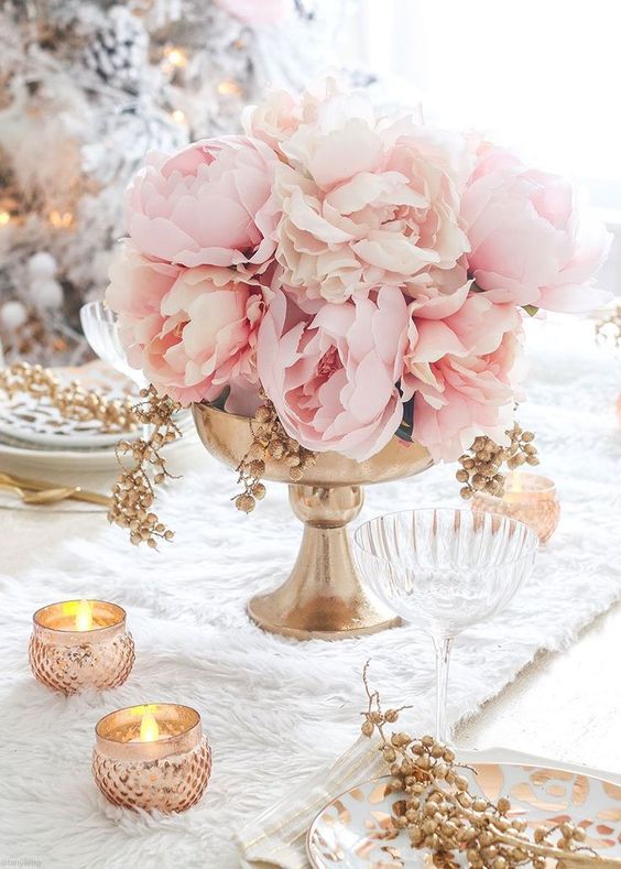 a refined wedding centerpiece of a gold bowl and lush pink peonies plus candles around is a very beautiful summer wedding idea