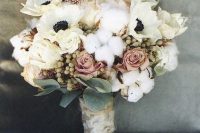 a refined winter wedding bouquet of white anemones, cotton, berrries, dusty pink roses and pale leaves with a burlap wrap