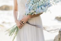 a romantic coastal bridal look with a strapless embellished wedding dress and a white and blue long stemmed wedding bouquet