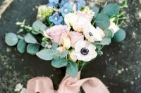 a romantic wedding bouquet of white anemones, pink roses, blue blooms and eucalyptus and blush ribbons is great for spring or summer
