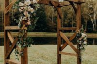 a rustic wedding altar of wood, with greenery, white and blush blooms, pampas grass is a lovely idea for a summer wedding