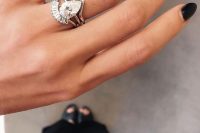 a sophisticated and modern stacked engagement ring with a large pear-shaped diamond, a triangle upper band and an arched diamond lower one