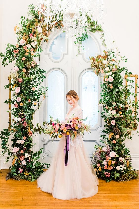 a sophisticated secret garden wedding arch of greenery, blush, orange and pink blooms is a gorgeous solution you can go for