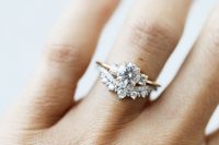 a sophisticated stacked wedding ring with a central round one and an arched diamond lower ring to frame it is chic and cool