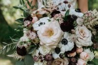 a statement wedding bouquet of dark blooms, blush and dusty pink roses, white anemones, various types of greenery will make an impression