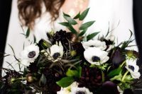 a stylish winter wedding bouquet of white anemones and dark blooms, greenery is a bold solution for a winter bride