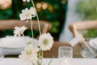 a super elegant wedding centerpiece of white blooms and white candles is a sophisticated idea for a spring or summer wedding