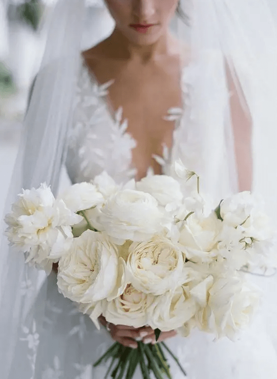 a super lush white wedding bouquet of ranunculus and peony roses is a gorgeous idea for any neutral wedding