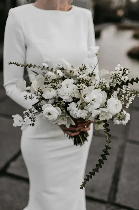 a trendy modern wedding bouquet of white blooms and lunarias plus greenery for a spring bride