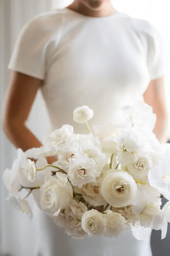 a white rose and ranunculus wedding bouquet with plenty of dimension looks cool and very modern
