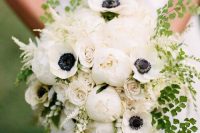 a white wedding bouquet of peonies, anemones, roses, greenery and blooming branches is a chic idea for a spring or summer wedding