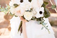 an elegant and chic spring or summer wedding bouquet of white roses, anemones and blush peonies with blush ribbons