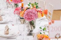bright secret garden wedding centerpieces of pink and orange blooms and tall candles will make the space bolder and cooler