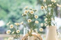 white vases with white daisies are lovely decorations for a relaxed rustic or boho summer wedding