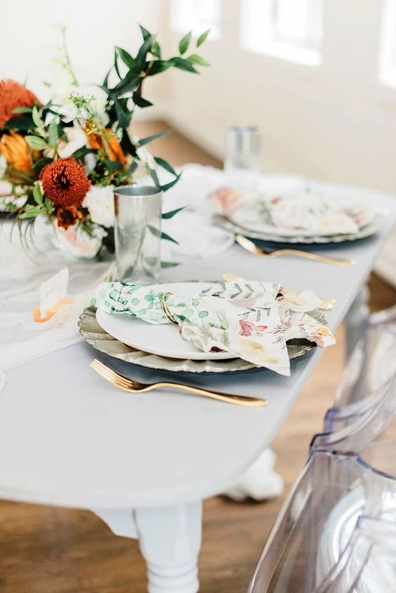 a beautiful and simple modern bridal shower tablescape with neutral porcelain and floral print napkins, bold blooms and greenery
