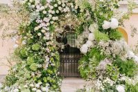 04 a breathtaking overgrown floral wedding arch with lots of textural greenery, twigs and branches and pastel blooms