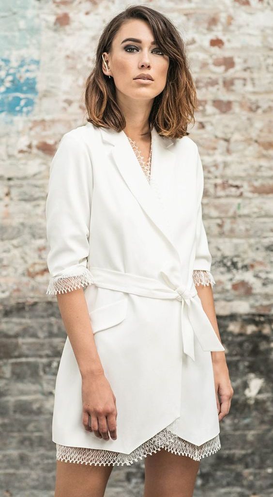 a white blazer mini wedding dress with a lace edge, short sleeves, a sash and statement accessories for a casual wedding