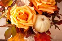 10 a rustic fall wedding centerpiece of a birch stump, orange roses, a pumpkin and bold fall leaves is a lovely and cozy idea