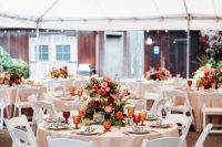 15 a bold fall wedding reception space with neutral linens, bold orange, burgundy and pink blooms and greenery and amber glasses