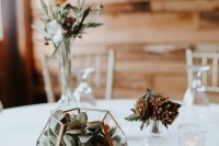 17 a modern fall wedding centerpiece of a terrarium with succulents, dried blooms and leaves, a rust flower and greenery in a vase