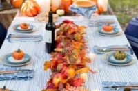 18 a bright fall wedding table setting in blues, with an appel and fall leaf table runner, candles and more pumpkins