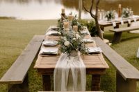 18 a delicate fall backyard wedding tablescape with candles, greenery and white blooms, white linens and string lights