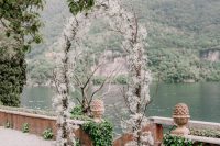 20 an ethereal wedding arch covered with twigs and lots of white blooms and with a fantastic view of Lake Como is wow